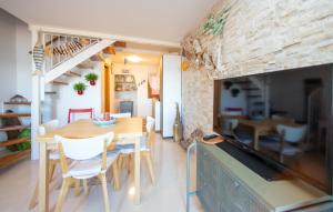 eine Küche und ein Esszimmer mit einem Tisch und einem TV in der Unterkunft Dimora Rubino in Pellestrina