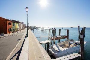 a boat parked at a dock next to the water at Dimora Rubino - Isola di Pellestrina Ve in Pellestrina