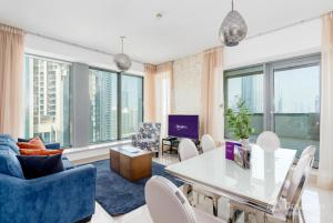 - un salon avec une table, des chaises et des fenêtres dans l'établissement Dream Inn Apartments - 29 Boulevard Private Terrace, à Dubaï