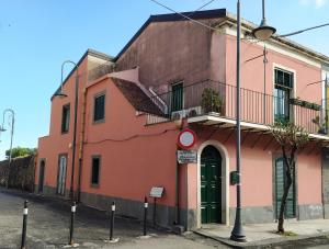 a pink building with a green door on a street at Blue Santa Tecla in Santa Tecla