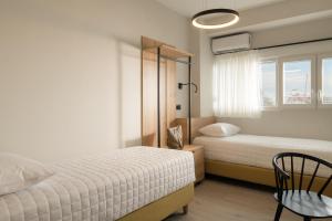 a bedroom with two beds and a chair and a window at Casa delle Palme in Rethymno Town