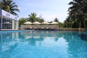 a large blue swimming pool with chairs and umbrellas at Scarlet Sails Resort in Koh Rong Island