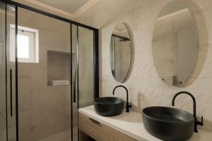a bathroom with two sinks and two mirrors at Casa delle Palme in Rethymno Town +26 photos