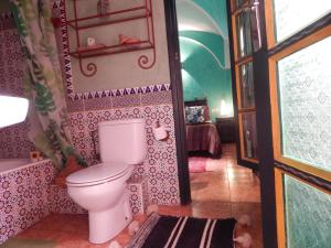 a bathroom with a toilet and a tub and a window at Casa del Sol Marrakech in Marrakech