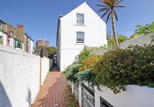 a white house with a palm tree on a street at Boho Apartment In The Lanes in Brighton & Hove