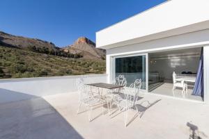 a patio with a table and chairs on a balcony at Casa vista alegre in Atarfe