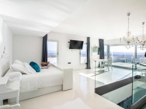 a white bedroom with a bed and a glass table at Casa vista alegre in Atarfe