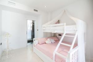a white bunk bed in a white room with a ladder at Casa vista alegre in Atarfe +38 photos
