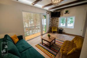 Una sala de estar con un sofá verde y una mesa. en Nirvana Čudesni bor, en Divčibare