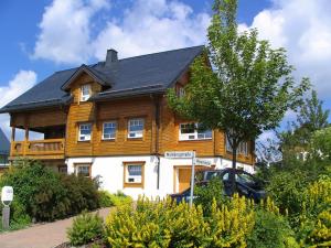 una casa de madera con un coche aparcado delante de ella en Berglodge für 10 Personen mit Sauna, en Sehmatal