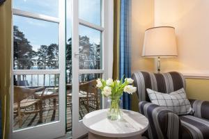 a living room with a vase of flowers on a table at Precise Resort Bad Saarow - Golf & Spa in Bad Saarow