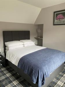 a bedroom with a large bed with a blue blanket at Campfield House in Fort William