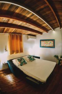 un grande letto in una camera con soffitto in legno di Bungalow de Nola a Le Lamentin