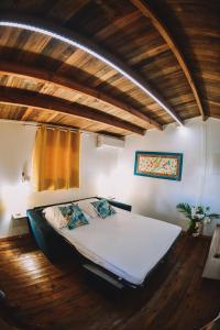 duże łóżko w pokoju z drewnianą podłogą w obiekcie Bungalow de Nola w mieście Le Lamentin