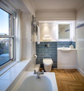uma casa de banho com uma banheira, um WC e um lavatório. em The Bruntsfield Hotel em Edinburgo
