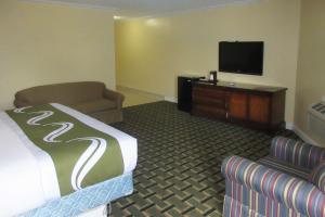 a hotel room with a bed and a couch and a tv at Quality Inn in Harrodsburg