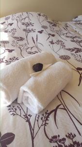 ein Bett mit Handtüchern darauf mit einer Decke in der Unterkunft Klintholm Bed & Breakfast in Borre