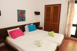 2 Betten mit bunten Kissen auf einem Zimmer in der Unterkunft Villa Jacaranda - 550m from the beach - Free WIFI - By Bedzy in Albufeira