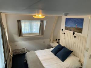 - une petite chambre avec un lit et une fenêtre dans l'établissement Hotel Het Gouden Boltje, à De Koog