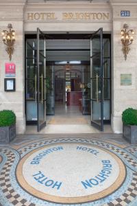 a hotel entrance with a sign in front of it at Hôtel Brighton - Esprit de France in Paris