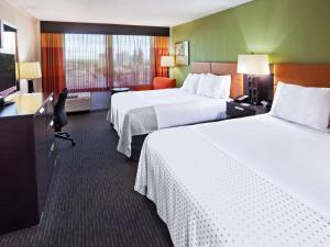 a hotel room with two beds and a television at 17 West Hotel, Ascend Hotel Collection in Tulsa