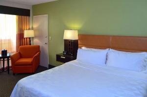 a hotel room with a large bed and a chair at 17 West Hotel, Ascend Hotel Collection in Tulsa