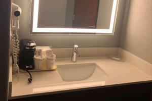 a sink in a bathroom with a mirror at AmericInn by Wyndham New Braunfels in New Braunfels