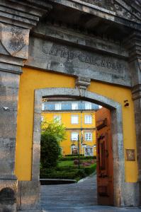 une entrée à un bâtiment jaune avec une arche dans l'établissement Hotel Casa da Calçada Relais & Chateaux, à Amarante