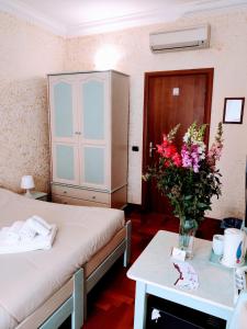Zimmer mit 2 Betten und einem Tisch mit Blumen in der Unterkunft St. Peter's Rooms Rome in Rom