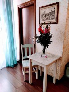 ein Tisch und Stühle mit einer Blumenvase drauf in der Unterkunft St. Peter's Rooms Rome in Rom