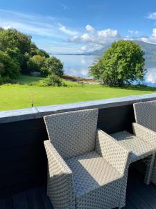 two chairs on a balcony with a view of the water at Campfield House in Fort William