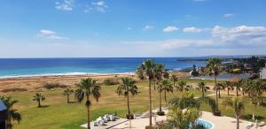 a view of a beach with palm trees and the ocean at Anmaria Beach Hotel & Spa in Ayia Napa