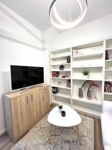 sala de estar con TV y mesa blanca en Hot Spot - Premium Loft - Sanador Victoriei, en Bucarest