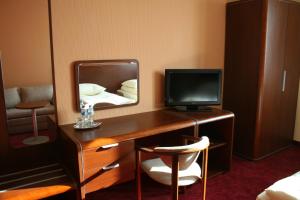 a room with a desk with a tv and a mirror at Impresja in Borek Wielkopolski