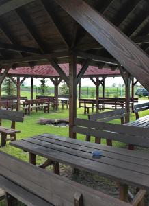 a group of wooden picnic tables in a field at Impresja in Borek Wielkopolski