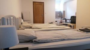 3 camas sin hacer en una habitación con TV en Omega Szigetszentmiklós, en Szigetszentmiklós