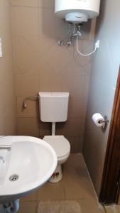 ein Badezimmer mit einem weißen WC und einem Waschbecken in der Unterkunft Omega Szigetszentmiklós in Szigetszentmiklós