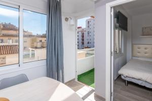 een klein appartement met een balkon, een bed en een raam bij Nice 3BR in Fuengirola Centre near the beach in Fuengirola