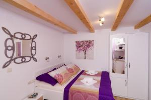 a small bedroom with a bed and a cabinet at Lavender Garden Apartments in Dubrovnik