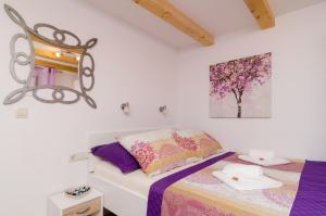 - une chambre avec un lit et une peinture murale dans l'établissement Lavender Garden Apartments, à Dubrovnik