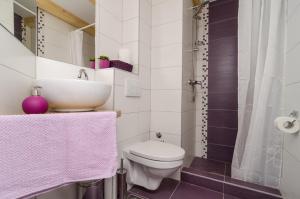 a bathroom with a white toilet and a sink at Lavender Garden Apartments in Dubrovnik +37 photos
