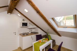 a small kitchen with a table and chairs in a attic at Lavender Garden Apartments in Dubrovnik