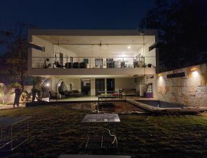 a large house with a balcony and a yard at night at Kondekar's WEEKEND HOME in Kolhapur