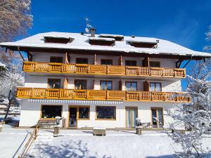 un edificio con un balcón sobre la nieve en Hotel Carossa bed&breakfast, en Sankt Gilgen