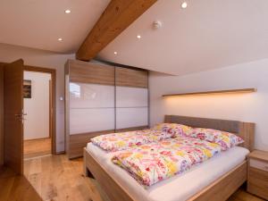 a bedroom with a large bed with colorful sheets at Wegrainhof in Kirchberg in Tirol