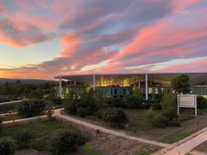 un bâtiment avec un coucher de soleil dans le ciel dans l'établissement thecamp Hôtel & Lodges - Aix en Provence, à Aix-en-Provence