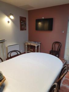 a room with a table and a tv on the wall at le domaine de bellevue in Tanzac