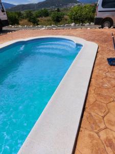 - une piscine d'eau bleue dans la cour dans l'établissement Andalusian farmhouse with barbecue, pool and wifi, à Malaga