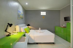 a bedroom with a bed and a desk with a lamp at Negara Hotel - CHSE Certified in Negara