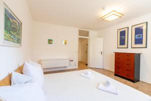 a bedroom with a large white bed and a dresser at Serviced Appartement München Messe in Munich